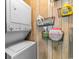 Laundry room with a stacked washer and dryer and storage racks on wood paneled wall at 4350 Intercoastal Dr. # 2207, Little River, SC 29566