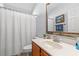 Cozy bathroom featuring a wooden vanity, framed mirror, and shower with a white curtain at 4517 Planters Row Way, Myrtle Beach, SC 29579