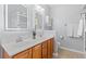 This bathroom features a wooden dual sink vanity, tile floors, and matching, illuminated vanity mirrors at 4517 Planters Row Way, Myrtle Beach, SC 29579