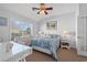 Bright bedroom with a queen-sized bed, neutral paint, a ceiling fan, and a large window at 4517 Planters Row Way, Myrtle Beach, SC 29579