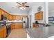 Well-lit kitchen features wood cabinets, stainless steel appliances, and a breakfast bar for seating at 4517 Planters Row Way, Myrtle Beach, SC 29579