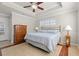 Comfortable main bedroom with a tray ceiling, tiled floors, a window, and a charming decor at 4517 Planters Row Way, Myrtle Beach, SC 29579