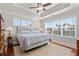 Comfortable main bedroom with a tray ceiling, tiled floors, two windows, and a charming decor at 4517 Planters Row Way, Myrtle Beach, SC 29579