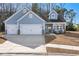 Charming light-blue home with a three-car garage and inviting front porch, showcasing curb appeal at 5501 Bristle Cone Ct., Myrtle Beach, SC 29577