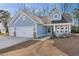 Inviting light-blue home featuring a spacious three-car garage and a cozy, welcoming front porch at 5501 Bristle Cone Ct., Myrtle Beach, SC 29577