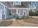 Close-up of the cozy front porch with white columns and railing of this charming light-blue house at 5501 Bristle Cone Ct., Myrtle Beach, SC 29577