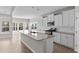 Open-concept kitchen with granite countertops, stainless steel appliances, and an island overlooking a bright, window-filled area at 5501 Bristle Cone Ct., Myrtle Beach, SC 29577