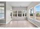 Bright sunroom with wood-look floors and large windows, offering serene views of the outdoors and natural light at 5501 Bristle Cone Ct., Myrtle Beach, SC 29577