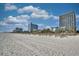 Expansive sandy beach with a view of high-rise buildings in the distance at 5523 N Ocean Blvd. # 1513, Myrtle Beach, SC 29577