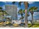 Ocean Forest Plaza condo building with lush landscaping, palm trees, and signage on a bright, sunny day at 5523 N Ocean Blvd. # 1513, Myrtle Beach, SC 29577