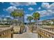 Scenic boardwalk leads towards a high-rise building, complemented by lush palm trees at 5523 N Ocean Blvd. # 1513, Myrtle Beach, SC 29577