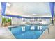 Bright indoor pool area with lounge seating, hot tub and access to outdoor area with lush greenery at 5523 N Ocean Blvd. # 1513, Myrtle Beach, SC 29577
