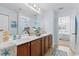 Bathroom with double sinks, brown cabinets, mirror, decor and view to bedroom at 556 Cedar Lakes Dr., Little River, SC 29566
