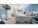 Coastal bedroom featuring a queen bed, blue accent wall, and light-colored furniture with TV at 556 Cedar Lakes Dr., Little River, SC 29566