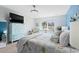 Bright coastal bedroom featuring a queen bed, blue accent wall, and light-colored furniture, and large windows at 556 Cedar Lakes Dr., Little River, SC 29566
