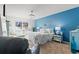 Coastal bedroom featuring a queen bed, blue accent wall, and light-colored furniture and bright light at 556 Cedar Lakes Dr., Little River, SC 29566
