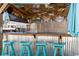 Outdoor poolside bar with seating and refrigerator, decorated with beach themed decor and shade at 556 Cedar Lakes Dr., Little River, SC 29566