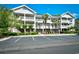 Attractive condo building with multiple balconies and mature landscaping near parking lot at 5801 Oyster Catcher Dr. # 723, North Myrtle Beach, SC 29582