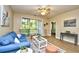 Comfortable living room with light wood flooring, bright blue couch, and sliding glass doors at 5801 Oyster Catcher Dr. # 723, North Myrtle Beach, SC 29582