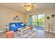 Bright living room with light wood flooring, comfortable furniture, and access to a private balcony at 5801 Oyster Catcher Dr. # 723, North Myrtle Beach, SC 29582