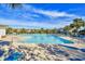 Community pool is surrounded by palm trees, landscaping, and lounge chairs at 5801 Oyster Catcher Dr. # 723, North Myrtle Beach, SC 29582