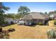 Aerial view of a brick home featuring a screened porch and large backyard at 598 Summer Green Ct., Sunset Beach, NC 28468