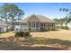 Backyard view of a brick home featuring a screened porch and manicured landscaping at 598 Summer Green Ct., Sunset Beach, NC 28468