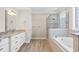 Bright bathroom with a soaking tub, glass enclosed shower, and wood-look flooring at 598 Summer Green Ct., Sunset Beach, NC 28468