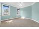 Light blue bedroom with neutral carpet, ceiling fan, and two windows overlooking the outdoors at 598 Summer Green Ct., Sunset Beach, NC 28468
