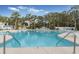 Large swimming pool with lounge chairs, umbrellas, and palm trees in a resort-style setting at 598 Summer Green Ct., Sunset Beach, NC 28468