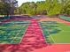 Outdoor tennis courts in great condition and surrounded by green trees at 598 Summer Green Ct., Sunset Beach, NC 28468