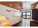 Bright bedroom with wood ceiling, king bed and a view of greenery out the large sliding glass doors at 604 Ocean Boulevard W, Holden Beach, NC 28462