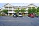 Exterior view of a condominium complex featuring multiple stories and ample parking spaces at 6203 Catalina Dr. # 1811, North Myrtle Beach, SC 29582
