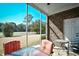 Screened-in patio with red-cushioned seating, brick siding, and a clear view of the adjacent golf course at 6203 Catalina Dr. # 1811, North Myrtle Beach, SC 29582