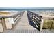 Wooden boardwalk leads to the beach, showcasing easy access to sandy shores and ocean views at 63 Mckissick Dr. # 2B, Pawleys Island, SC 29585