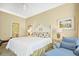 Inviting bedroom with white headboard, tropical artwork, side tables, and a comfortable chair near the windows at 63 Mckissick Dr. # 2B, Pawleys Island, SC 29585