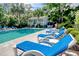 Relaxing community pool area features lounge chairs, palm trees, and a charming pool house at 63 Mckissick Dr. # 2B, Pawleys Island, SC 29585