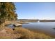 Scenic waterway view with a small wooden dock showcasing serene landscape and nearby homes at 63 Mckissick Dr. # 2B, Pawleys Island, SC 29585