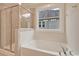 Modern bathroom with a shower and soaking tub combo, complemented by natural light from a window at 67 Bridgeview Rd., Georgetown, SC 29440