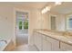 Bathroom featuring double sinks with granite countertop and cabinets, with a glimpse into the bedroom at 67 Bridgeview Rd., Georgetown, SC 29440