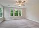 Spacious bedroom with large windows offering ample natural light and a serene view of lush greenery at 67 Bridgeview Rd., Georgetown, SC 29440