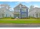 Inviting two-story blue home with well-kept lawn, accented by white trim and a cozy porch at 67 Bridgeview Rd., Georgetown, SC 29440
