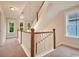 Bright hallway with wood and white banister, carpeted floor, and natural light from windows at 67 Bridgeview Rd., Georgetown, SC 29440