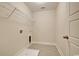 Compact laundry room with tile floor, shelving, and utility connections at 67 Bridgeview Rd., Georgetown, SC 29440