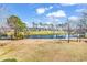 An elevated view of a pond and golf course, surrounded by trees, on a sunny day at 699 Riverwalk Dr. # 202, Myrtle Beach, SC 29579