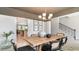 Elegant dining room with modern chandelier and view into the adjacent kitchen and stairway at 7071 Shooting Star Way, Myrtle Beach, SC 29579