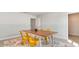 Well-lit dining area with a wooden table, yellow chairs, and a decorative rug, adjacent to a walk-in closet at 7071 Shooting Star Way, Myrtle Beach, SC 29579