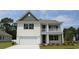 Charming two-story home showcasing a porch, two-car garage, and manicured lawn at 7071 Shooting Star Way, Myrtle Beach, SC 29579