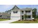 Charming two-story home showcasing a porch, two-car garage, and manicured lawn at 7071 Shooting Star Way, Myrtle Beach, SC 29579
