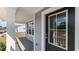 Inviting front porch features gray floors, gray siding, black door with glass, and white trim on a well lit sunny day at 7071 Shooting Star Way, Myrtle Beach, SC 29579